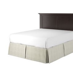 a bed with a white bedspread and brown headboard