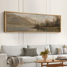 a living room with a couch, coffee table and painting on the wall above it