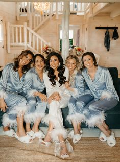 the bride and her bridesmaids pose for a photo in their matching blue robes