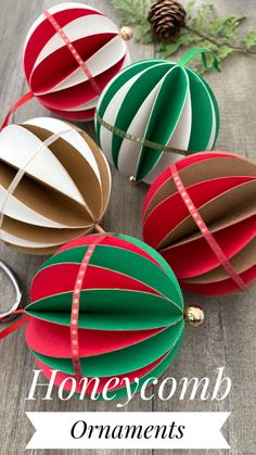 three origami hot air balloons with tape on them and pine cones in the background