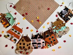 a white table topped with lots of different types of felt houses and buildings on top of each other