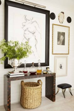 a table with some vases and pictures on the wall