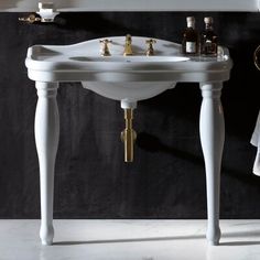 a white sink sitting under a mirror next to a wall mounted faucet in a bathroom