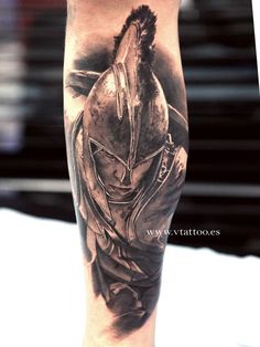 a man's leg with a spartan tattoo on it