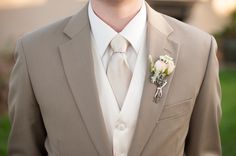 a man in a suit and tie with a boutonniere on his lapel