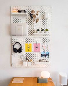 a wooden desk with headphones on it next to a wall mounted shelf filled with books