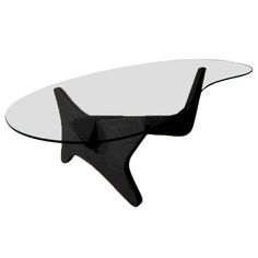 an oval glass table with black legs and a curved design on the top, against a white background