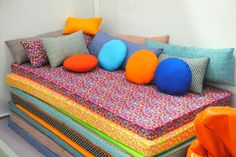 a multicolored couch with many pillows on it