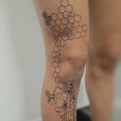 a woman's leg with honeycombs and flowers on it