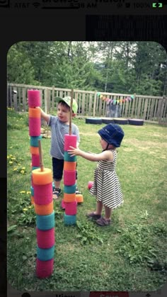 two young children playing with giant blocks in the yard