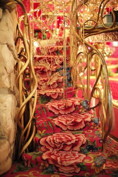 an elaborately decorated stair case with red flowers and vines on it's sides