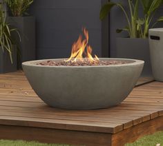 a fire pit sitting on top of a wooden deck next to potted planters