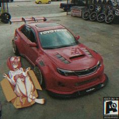 a red car parked next to a cardboard box