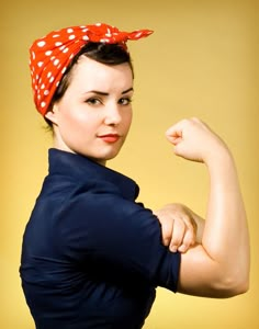 a woman with a red bandana on her head and arms is posing for the camera