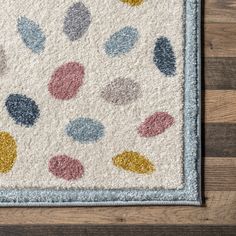 a white rug with multi colored dots on it