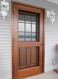 a wooden bench sitting on the front porch next to a door with glass panes