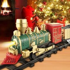 a toy train is on the tracks near a christmas tree