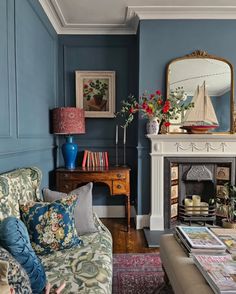 a living room filled with furniture and a fire place in front of a blue wall