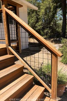 wooden steps leading up to a house with metal handrails and gated railing