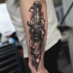 a person with a tattoo on their arm holding a knife