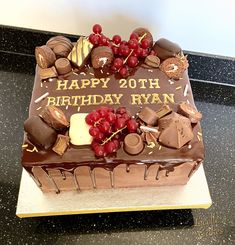 a birthday cake with chocolate and cherries on it