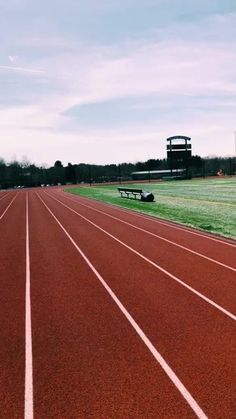 an empty track with a bench in the distance