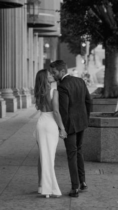 a man and woman kissing on the street