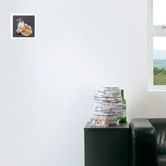 a room with white walls and a black leather chair next to the wall is a window that has an image of a cow on it