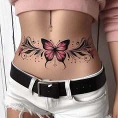 a woman's stomach with a pink butterfly tattoo on her belly and white shorts