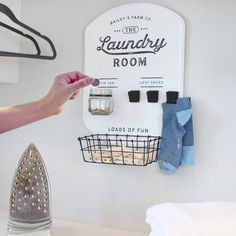 This charming metal sign is perfect for adding a rustic touch to your laundry room decor. Measuring 17.25 inches tall by 13.25 inches wide, it features a white enamelware background with bold black lettering that reads "Bailey's Farm Co., the Laundry Room". The sign also includes a handy wire basket at the base, which can be used to store laundry odds and ends. One of the most charming features of this sign is the "Lost Socks" section, which is adorned with three magnet clips where you can attac Laundry Room Sock Organization, Laundry Countertop Decor, Organization Laundry Room, Laundry Reno, Laundry Quotes, Laundry Room Design Ideas, Laundry Room Decorating, Organization Laundry, Laundry Room Sign