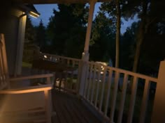 the porch is lit up at night with some lights on and there are no people outside