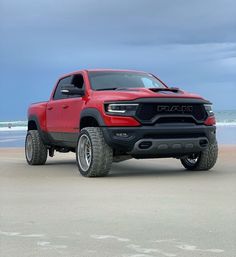 a red ram truck parked on the beach