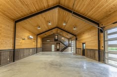 an empty garage with wood paneling and windows on both sides, leading to the second floor