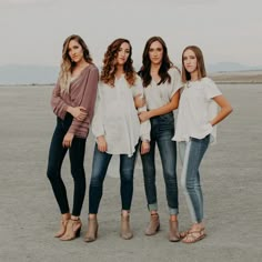 three women standing next to each other in the desert