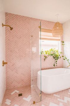 a bathroom with pink tiles and a white tub