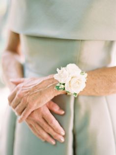 a close up of a person wearing a dress and holding a flower in their hand