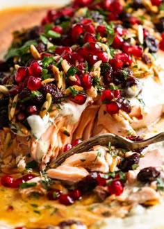 a white plate topped with meat covered in cranberry sauce and garnish