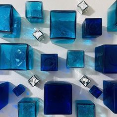 blue glass blocks are arranged on a white surface