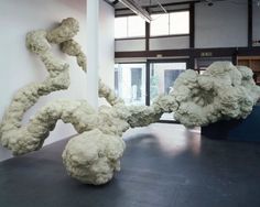 two large white sculptures in an empty room