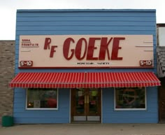 a blue building with a red and white awning that says p f coeke