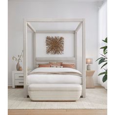 a large white bed sitting on top of a wooden floor