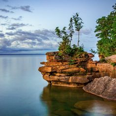 the water is crystal blue and clear as it sits next to some large rock formations