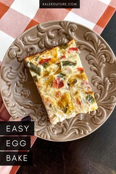 a piece of quiche on a plate with a woman's hand pointing at it