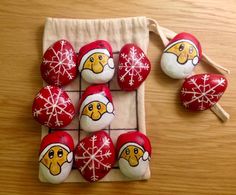 some red and white rocks with santa hats on them next to a drawstring bag