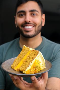 a man holding a plate with a piece of cake on it