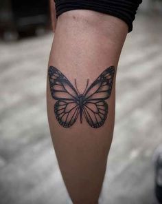 a woman's leg with a tattoo of a butterfly on the left side of her calf