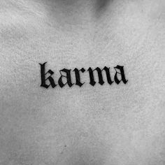 the word karma written in cursive ink on a man's chest