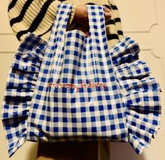 a person holding a blue and white checkered bag