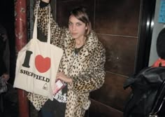 a woman holding up a tote bag with i love sheffield on it