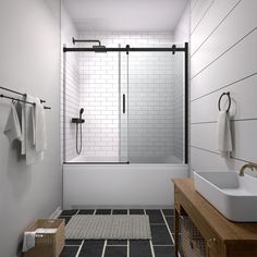 a white bathroom with black and white tile flooring, two sinks and a walk in shower